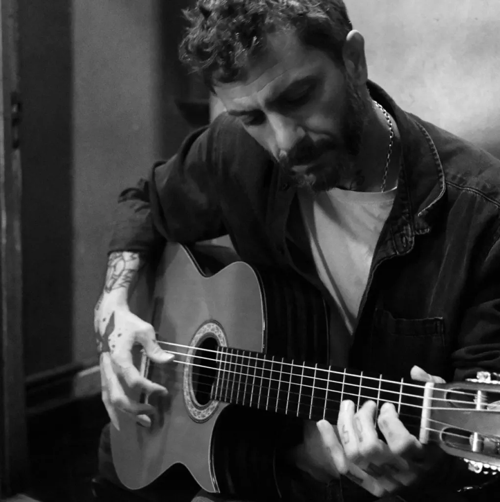Juan Medina tocando la guitarra, manos sobre las cuerdas